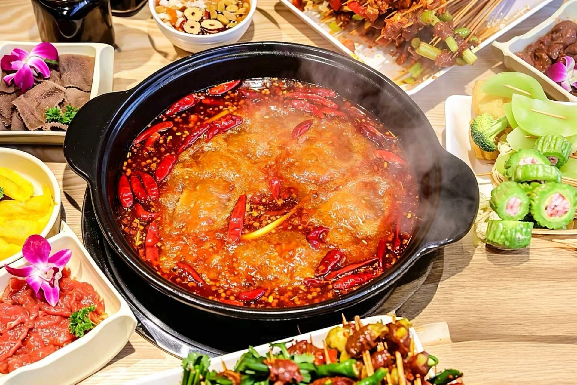 A bubbling pot of Sichuan hot pot — crimson broth studded with chilies and Sichuan peppercorns